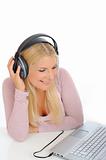 Pretty young girl listening to the music with headphones from he