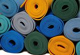 many colorfull yoga mats as a background. isolated on white back