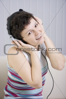 The girl listens to music in ear-phones