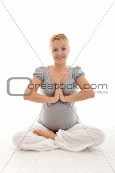 Beautiful pregnant woman doing exercises on the floor
