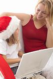 Woman and little girl playing with a laptop at christmas time