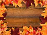 Autumn leaves frame on wood
