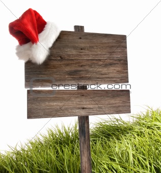 Weathered wooden sign with santa hat on white 