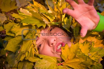 woman covered by autumnal leaves