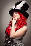 Attractive Red Haired Woman Wearing Bunny Ear Hat on a Grey Background.