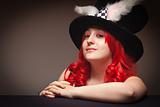Attractive Red Haired Woman Wearing Bunny Ear Hat on a Grey Background.