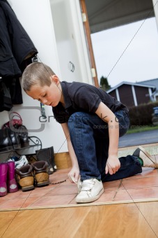 Little Boy tying his shoes