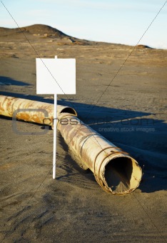 Sign near old rotting pipe - ecological disaster