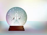 Glass ball with a snowman in a snowy landscape.