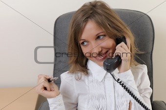 Young girl at office on the workplace makes call