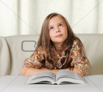 Little girl dreams when reading the book.