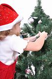 child decorating Christmas tree