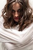 Young insane woman with straitjacket looking at camera close-up portrait