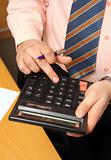 businessman counts money on calculator
