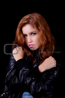 young and beautiful woman, with arm crossed in the form of an x, isolated on black background. Studio shot