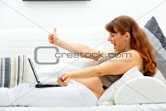 Happy beautiful pregnant female using credit card to shop from net
