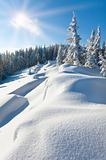 Snowdrifts on winter snow covered mountainside and sun