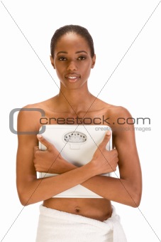 Black woman holding weight scales in front of her