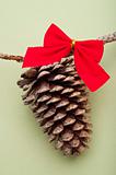 Holiday Pinecone with a Red Bow on a Green Background
