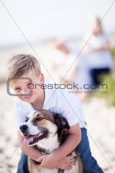 Handsome Young Boy Playing with His Dog at the Beach.
