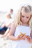 Adorable Little Blonde Girl with Starfish at The Beach.
