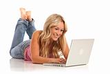Portrait of casual young girl with jeans laying on floor with laptop