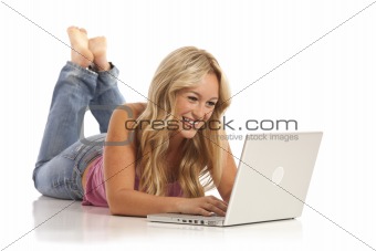 Portrait of casual young girl with jeans laying on floor with laptop