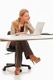 Young business girl sitting at desk with laptop