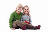 portrait of two young siblings looking at camera, smiling - isolated on white