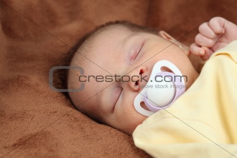 Newborn baby sleeping on soft brown blanket