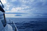 Boat sailing in cloudy stormy day blue ocean