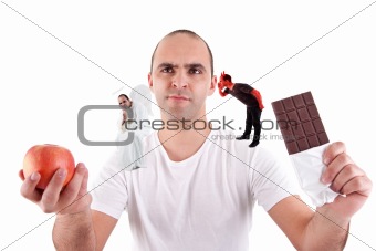 young man torn between eating an apple and a chocolate,between the devil and angel, on white