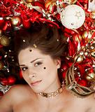 Beautiful brunette lying among christmas decoration