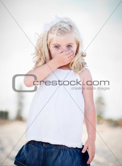 Adorable Blue Eyed Girl Covering Her Mouth Outside.