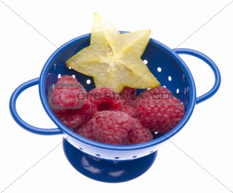 Fresh Raspberries and Carambola Starfruit in a Blue Colander