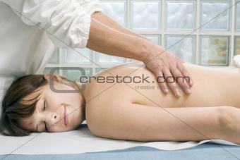 young caucasian woman lying down receiving back massage