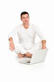 man dressed in white sitting on the floor with laptop