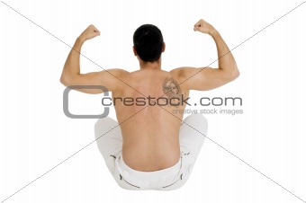 bare-chested man sitting on the floor shows the biceps