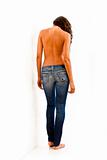 Back view of young woman with bare top wearing worn jeans