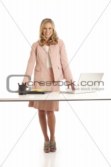 Young businesswoman with laptop standing at desk