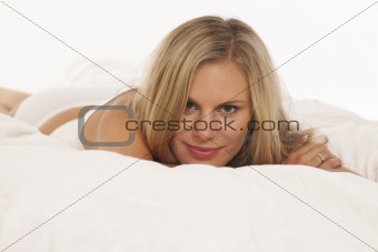 Portrait of young woman laying in bed