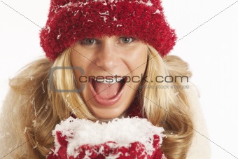 Portrait of young woman with red hat and gloves holding snow