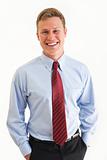 Portrait of young business man smiling with hands in pockets