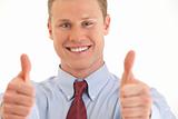 Portrait of smiling young businessman with two thumbs up