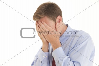 Portrait of stressed young businessman with hands over face