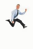 Smiling young businessman jumping in air with happiness