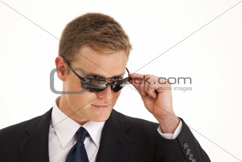 Head and shoulder portrait of young businessman wearing a suit and sunglasses