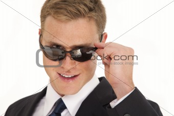 Head and shoulder portrait of young businessman wearing a suit and sunglasses
