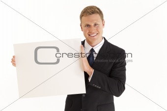Head and shoulder portrait of businessman holding blank sign
