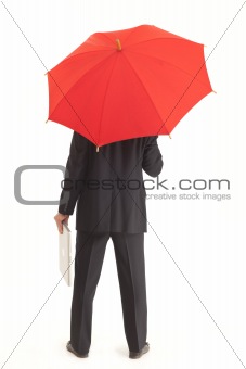 Back of businessman with red umbrella holding a laptop